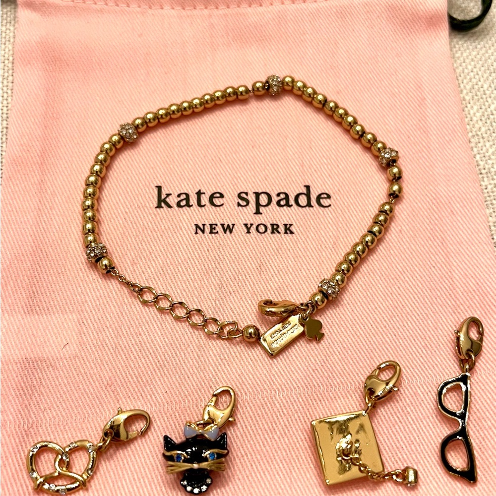 Kate Spade charm bracelet with 4 charms: cat, glasses, graduation cap, & pretzel